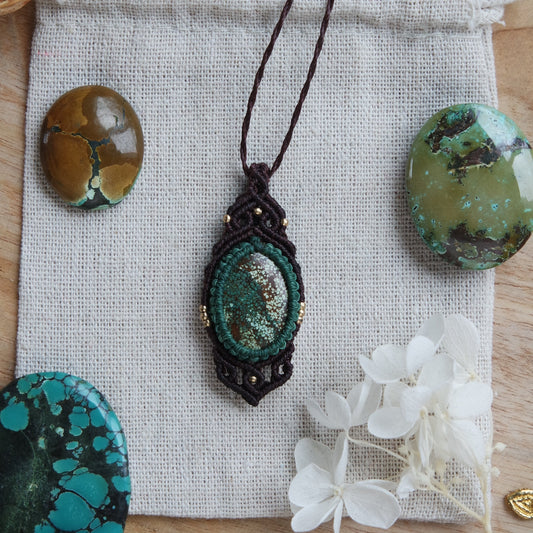 Detailaufnahme des Anhängers der Kette ‚Windfrau‘ – grünlich-blauer Türkisstein eingefasst in dunkelbraunes Makramee