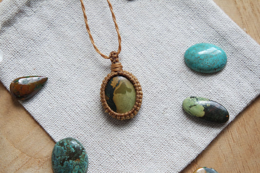 Makramee-Kette ‚Himmelssand‘ mit sandgrünem Türkisstein – handgeknüpft auf Leinentuch, umgeben von Edelsteinen