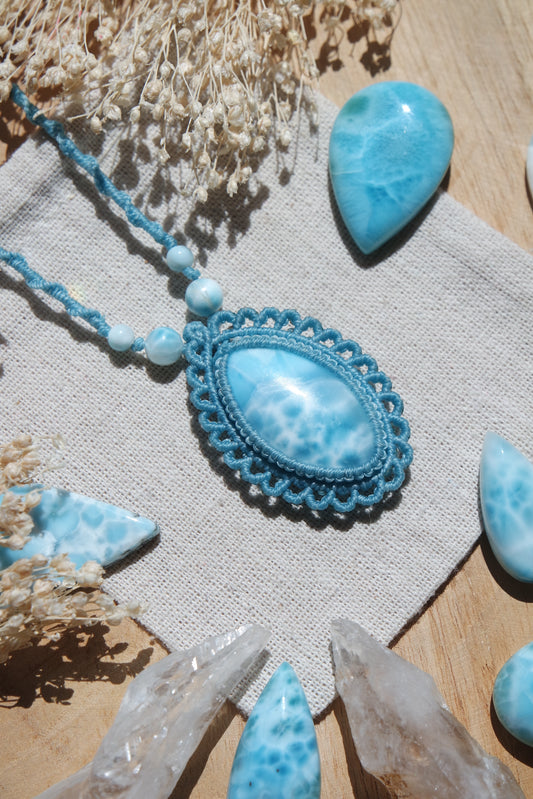 Kette „Meeresfrieden“ mit großem ovalem Larimar in hellblauer Makramee-Fassung auf Leinentuch.
