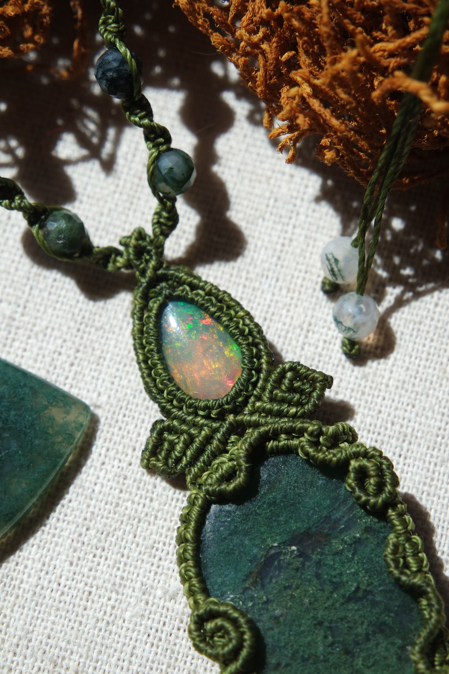 Nahaufnahme eines Opals im grünen Makramee eingefasst