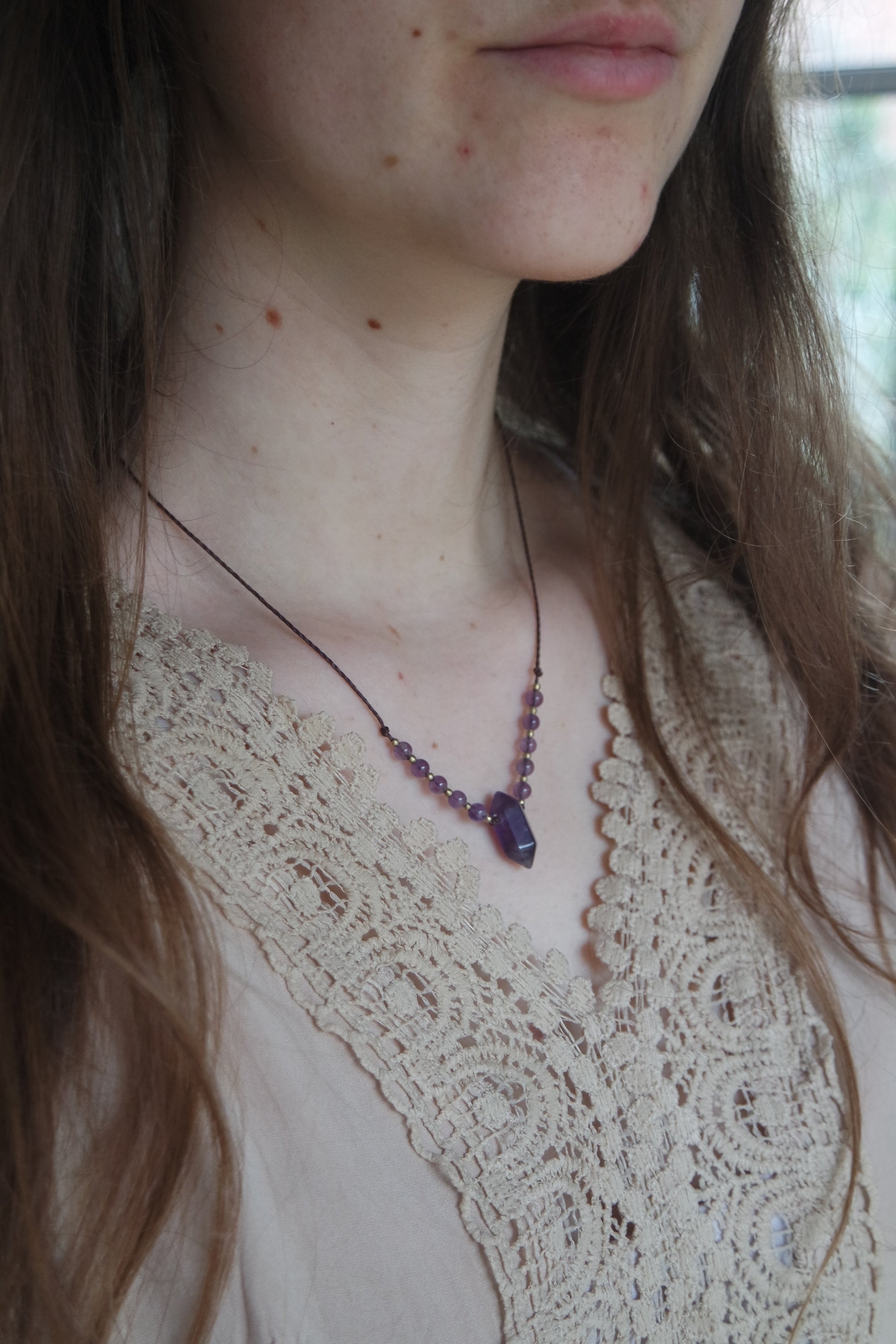 „Zarte Rosenquarz-Kette getragen, handgeknüpft im Makramee-Stil in natürlicher Farbe.“