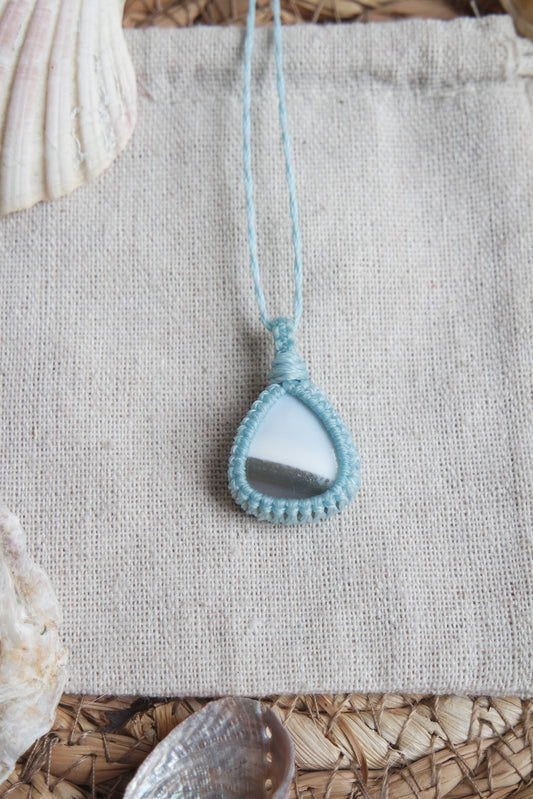 Makramee Kette „Leichtigkeit“ mit hellblauem Naturstein auf heller Leinenunterlage.