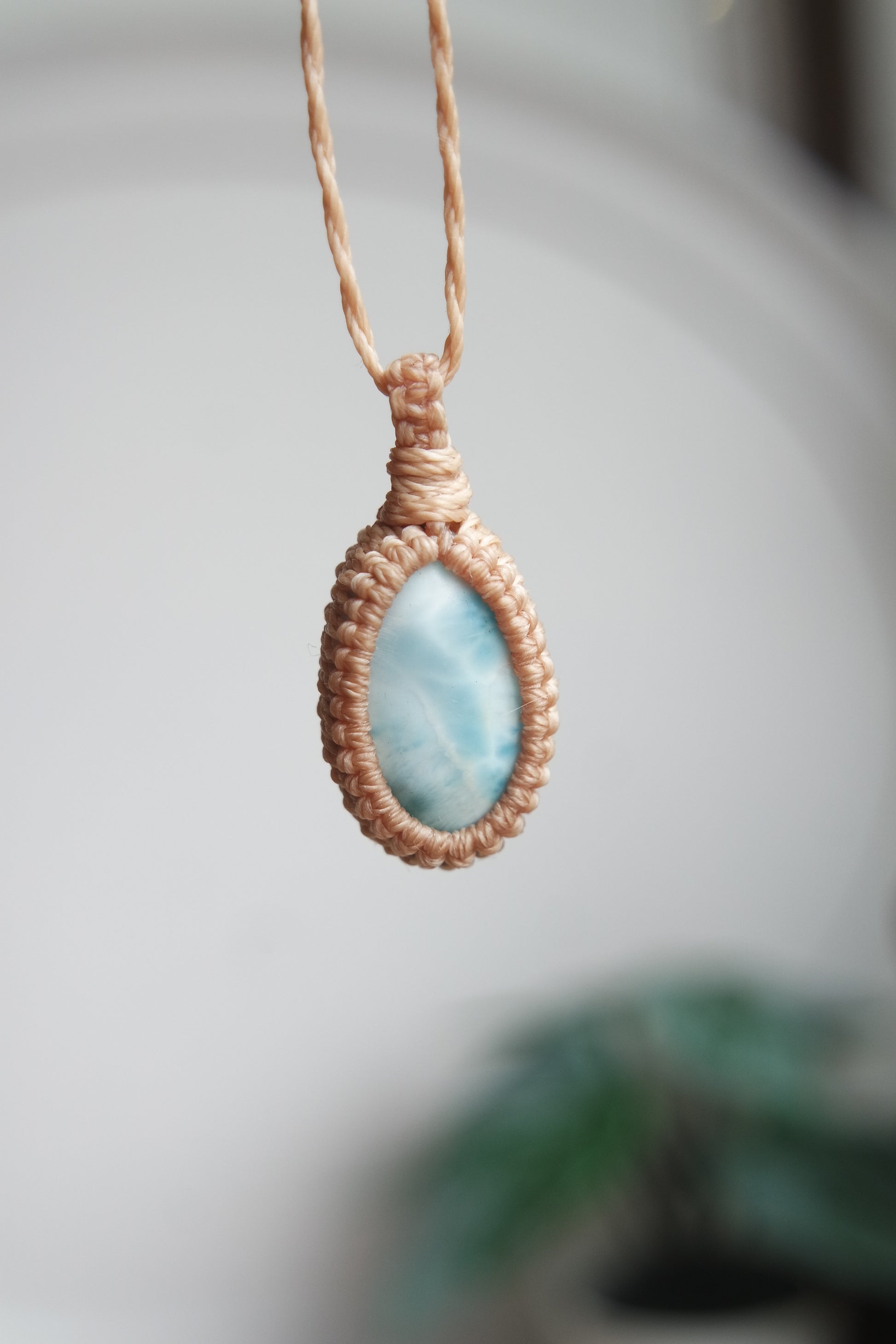 Larimar Kette mit beigefarbener Makrameefassung in Nahaufnahme.
