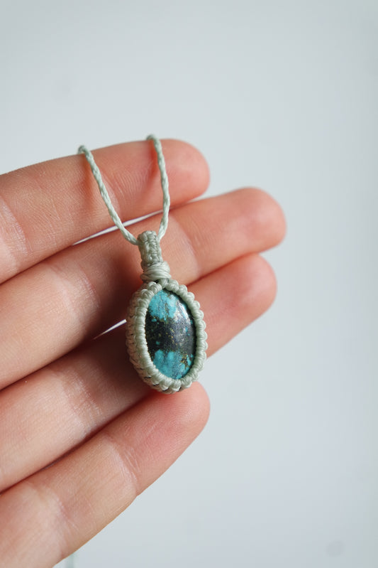 Kette ‚Stillewelle‘ mit türkisblauem Naturstein – filigran geknüpft und in einer Hand präsentiert