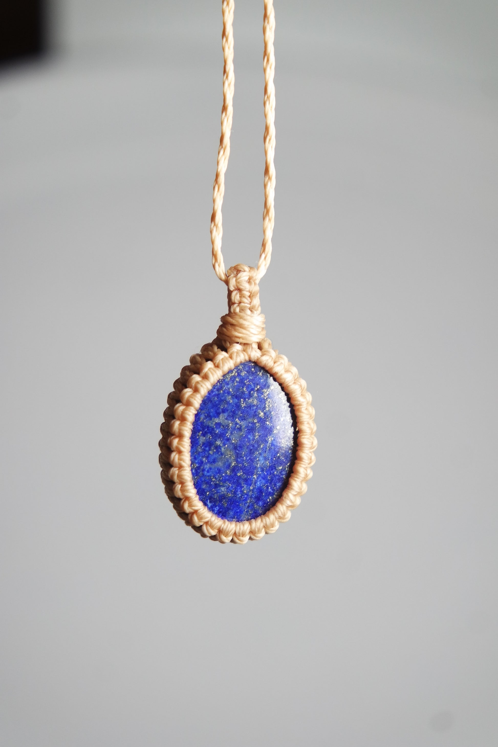 Handgefertigte Makramee Kette Aelith mit ovalem blauem Lapislazuli und heller Makramee Einfassung.