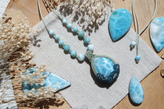 Kette „Wasserseele“ mit Larimar-Anhänger in grün-blauer Makramee-Fassung und Perlen auf Leinentuch.